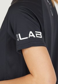 Zwarte sportieve shirt met korte mouwen, van een gestructureerde stof, met het 'ELITE LAB' logo in het wit op de mouw.