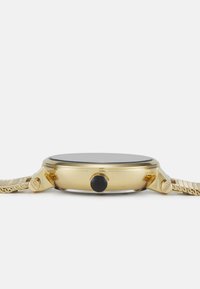 Montre-bracelet en or avec un boîtier rond, un cadran noir, un bracelet en métal texturé et deux boutons latéraux. Finition lisse avec un verre supérieur brillant.