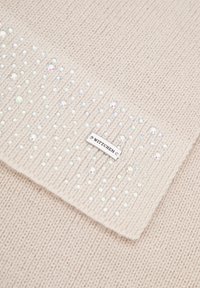 Écharpe beige tricotée avec un motif texturé agrémenté de strass transparents incrustés, et une étiquette métallique portant l'inscription "WITTCHEN".