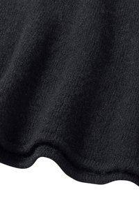 Schwarzer, gestrickter Stoff mit einer weichen Textur und gewelltem Rand. Das Material ist warm und kuschelig, geeignet für Kleidung oder Decken.