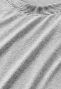 Tela de color gris claro con una textura suave, que presenta un cuello redondo acanalado y sutiles arrugas, destacando su suavidad y flexibilidad.