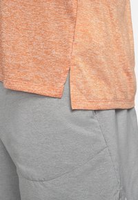 Nike Performance RISE - T-shirt desportiva - orange trance/htr/(reflective silv)