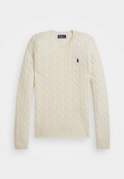 Crème-kleurige kabelgebreide trui met een ronde hals, ribgebreide manchetten en onderrand, voorzien van een klein marineblauw logo op de borst.