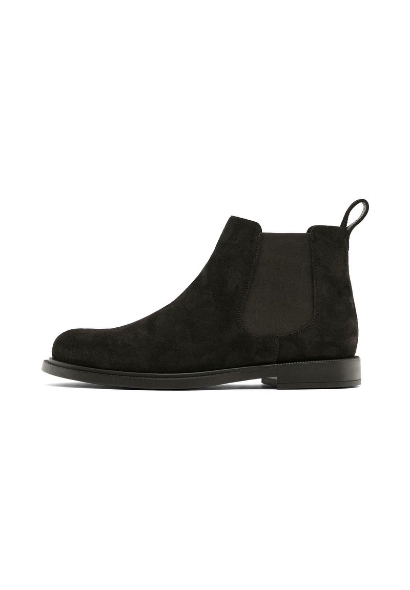 Stivale Chelsea in suede nero con pannello elastico laterale, linguetta sul tallone, tacco basso impilato e punta arrotondata, mostrato di profilo su sfondo bianco.