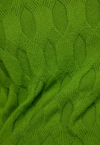 Grüner Strickstoff mit einem strukturierten Muster aus abwechselnden Rauten, der eine glatte, weiche Textur und lebendige Farbe zeigt.