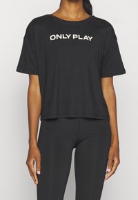 Camiseta negra de manga corta hecha de una tela suave con "ONLY PLAY" impreso en blanco en el pecho. Corte relajado con un dobladillo recto.