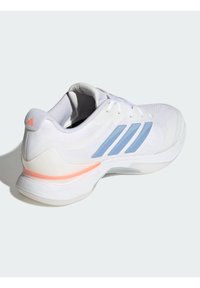 Άσπρο αθλητικό παπούτσι με υφή στο επάνω μέρος, γαλάζιες ρίγες και ροδακινί λεπτομέρεια στη φτέρνα. Διαθέτει επενδεδυμένη σόλα και άσπρα κορδόνια.