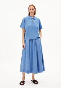 Blaue Jeans-Zweiteiler, bestehend aus einer kurzärmeligen, kragenlosen Bluse mit halbem Reißverschluss und einem langen Rock mit gerafftem Bund und Taschen.