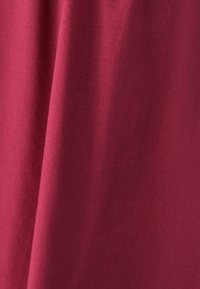 Bordo tkanina s glatkom teksturom, koja se lagano obara. Materijal izgleda lagano i ravnomjerno tkan bez vidljivih uzoraka ili naglasaka.