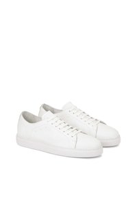 Valkoiset nahka sneakersit, joissa on pyöreä kärki, tasaiset nauhat ja ommeltu yksityiskohtia. Pehmeä sisävuori ja texturoitu kumipohja. Minimalistinen muotoilu.