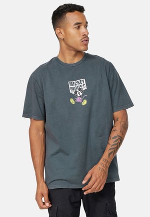 Camiseta de algodón gris con un estampado gráfico de Mickey Mouse en zapatos amarillos. Mangas cortas y un corte relajado.
