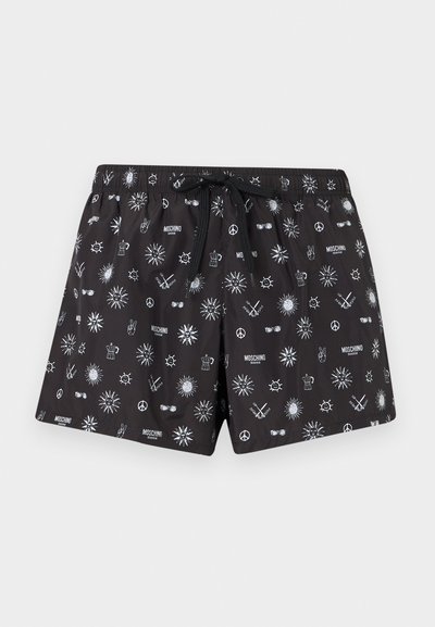 Sorte badeshorts med hvite mønstre av sol, fredstegn, kroner, solbriller og "Moschino Swim"-logoer over det hele, med svart snor i livet.