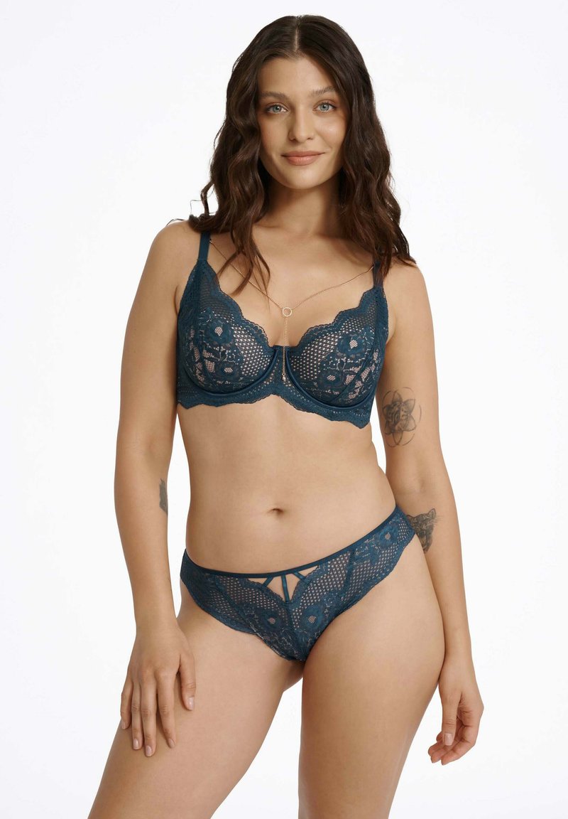 Turkusowy biustonosz i pasujące stringi z koronką, ozdobione wzorami kwiatowymi, regulowanymi ramiączkami oraz wycięciami dla dodatkowego efektu wizualnego.