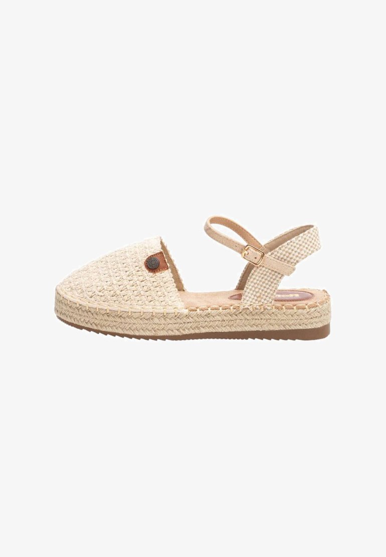 Sandalia de espadrille trenzada en beige con suela plana, correa ajustable en el tobillo y un acabado texturizado. Presenta un acento de logo redondo en el costado.
