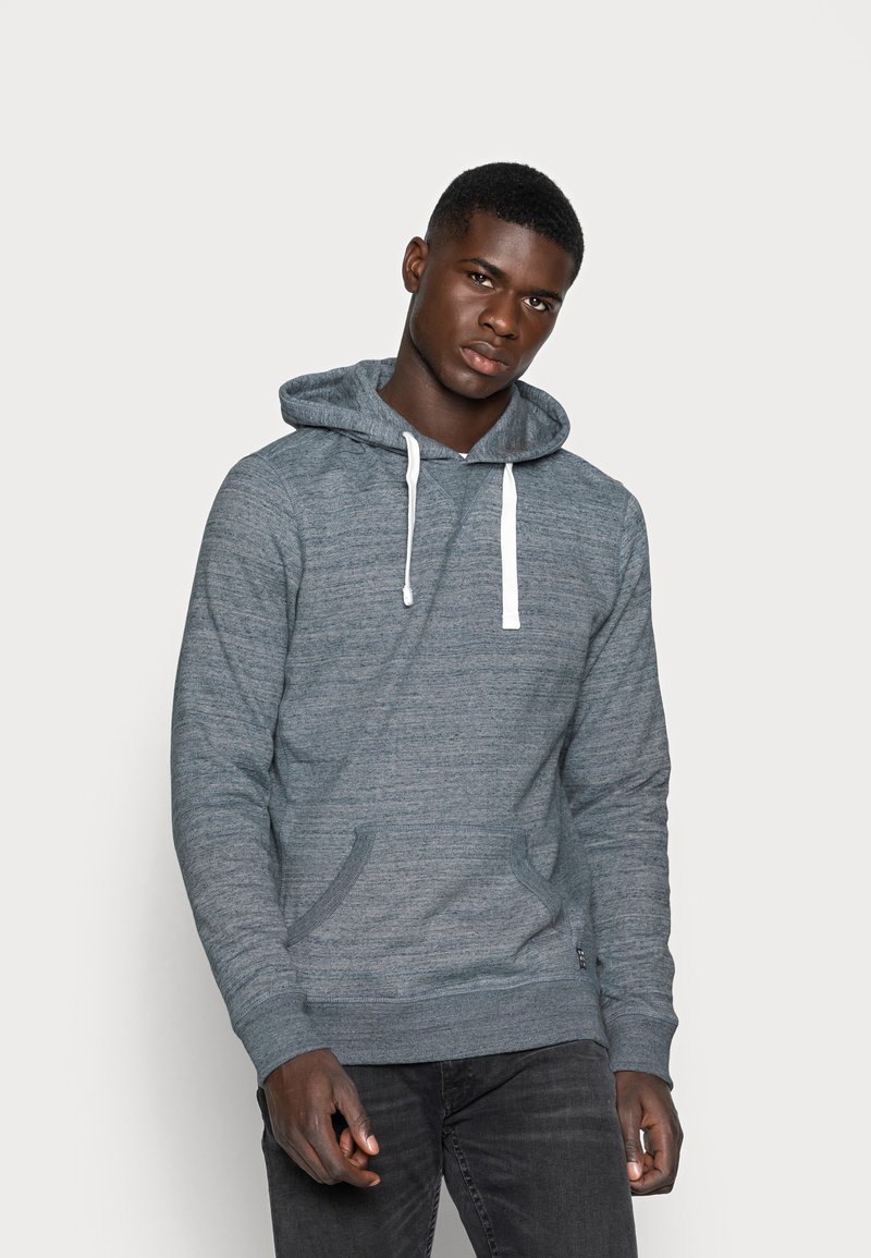 Hoodie grigio melange con tasca frontale, cordini bianchi e vestibilità rilassata. Il materiale sembra morbido con una trama liscia.