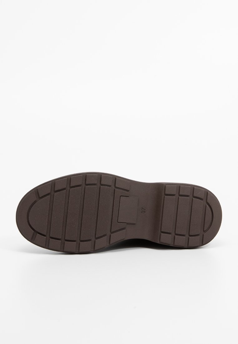 Braune Gummischuhsohle mit rechteckigen und zickzackförmigen Profilmustern, flachem Rand und zentralem Logo-Bereich. Glatte Textur mit robustem Finish.