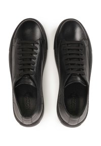 Mustad naha tennised, millel on sile viimistlus, nöörimise disain, ümardatud varvas ja tekstuuriga kummitald, koos diskreetse brändingu jaotusega sees.