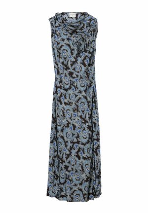 Giovane donna che indossa un vestito blu senza maniche con fantasia paisley, cintura nera, scarpe nere con calze, che tiene una grande borsa bordeaux su sfondo grigio.