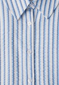 Camisa de botones con rayas verticales en azul y blanco. Tejido de algodón suave con un cuello clásico y botones blancos en el frente.
