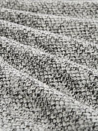 Getextureerde geweven stof in zwart-wit met een honden- of pied-de-poule-patroon. Het materiaal is zacht met een lichte glans en gevouwen voor dimensie.