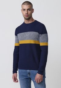 Navyblaue Rippstrickpullover mit grauen und gelben horizontalen Streifen. Hat einen Rundhalsausschnitt und lange Ärmel, aus einem strukturierten Strickstoff gefertigt.