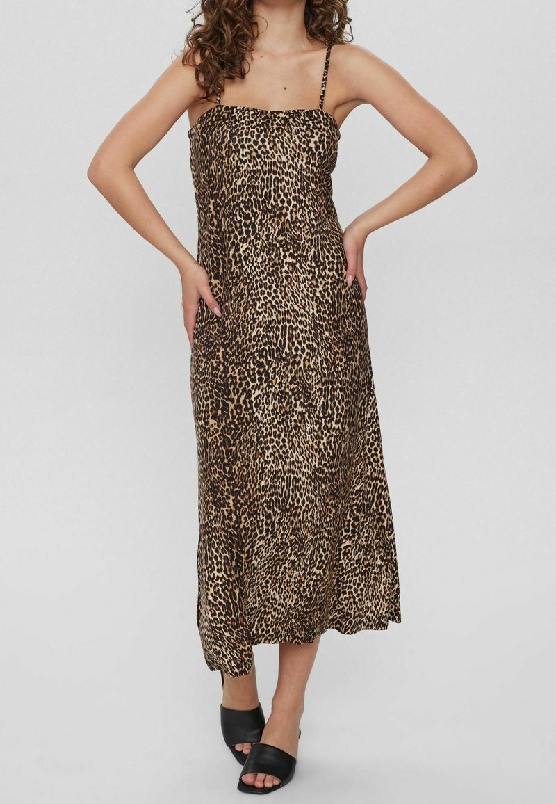 Vestido de media longitud con estampado de leopardo y tirantes finos, hecho de tejido ligero. Presenta un corpiño ajustado y una falda fluida, complementado con sandalias deslizantes negras.