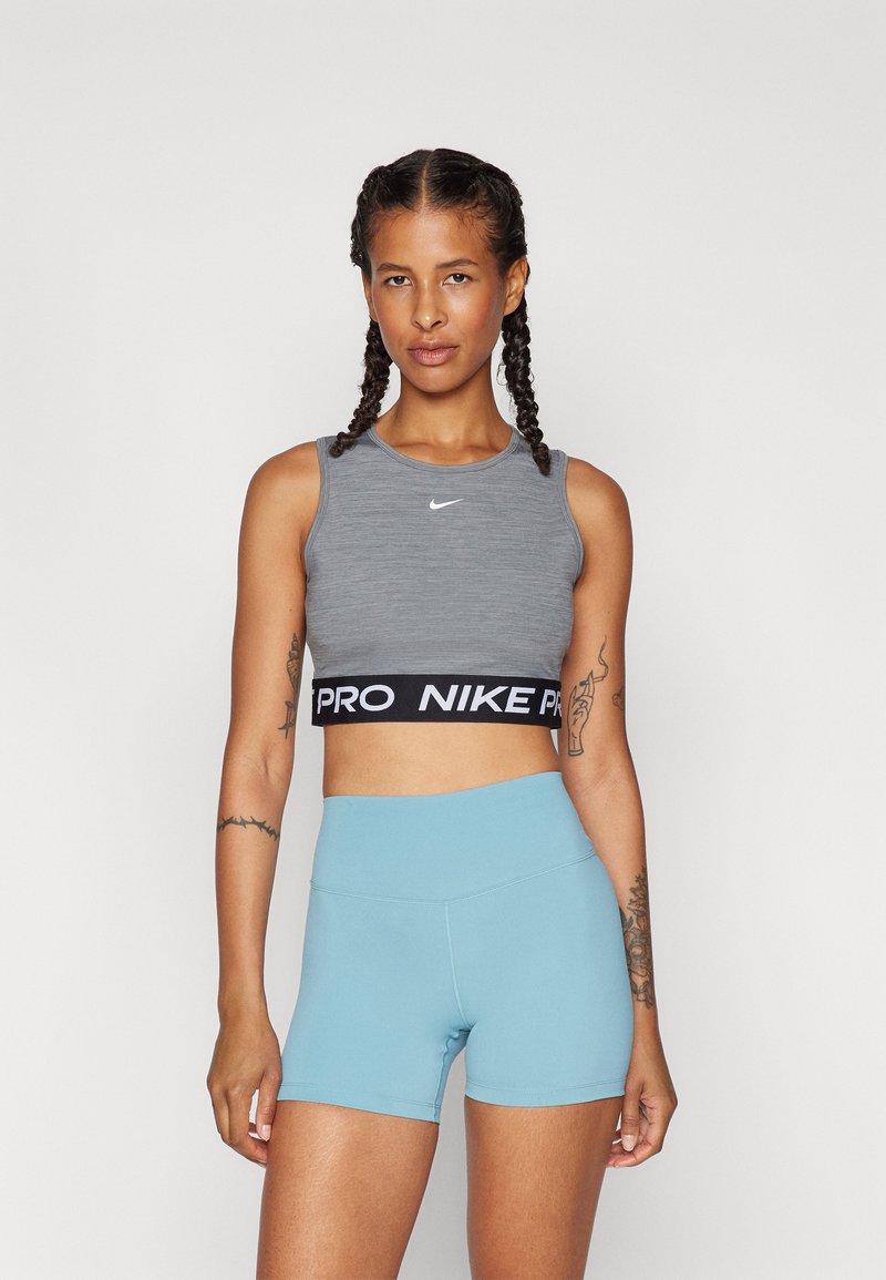 Szürke sportcrop felső fekete derékkal, amelyen a "PRO NIKE" felirat található, világoskék magas derekú rövidnadrággal, sima anyag, testhezálló fazon.