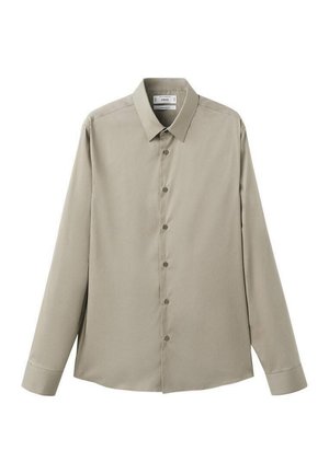 Košulja s dugim rukavima u svijetlo bež tkanini, ima klasični ovratnik, patentni zatvarač sprijeda i zaobljeni rub. Glatka tekstura.