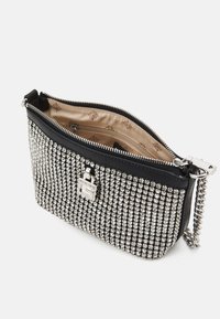 Czarna kopertówka ozdobiona srebrnymi cekinami, z zamknięciem na zamek i łańcuszkiem. Wnętrze wyłożone beżowym materiałem.