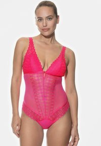 Rosa bodysuit med spetsdetaljer, djup V-ringning och mesh-paneldesign. Anmärkningsvärda detaljer inkluderar scalloperade kanter och dragkedja framtill.