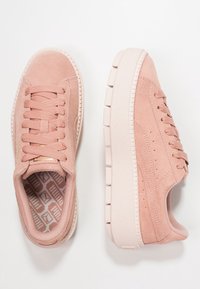 Helle rosa Wildledersneaker mit strukturiertem Sohlen, flachen Schnürsenkeln und minimalen Perforationsdetails. Weiches Innenfutter mit geometrischem Muster.