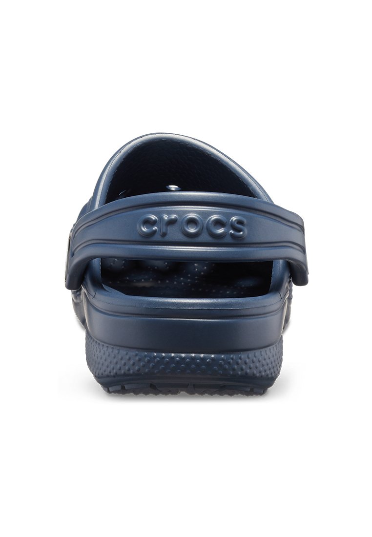 Donkerblauwe Crocs, gemaakt van flexibel materiaal, voorzien van een achterband, een textuur op de voetbed en ventilatiegaten aan de zijkanten.