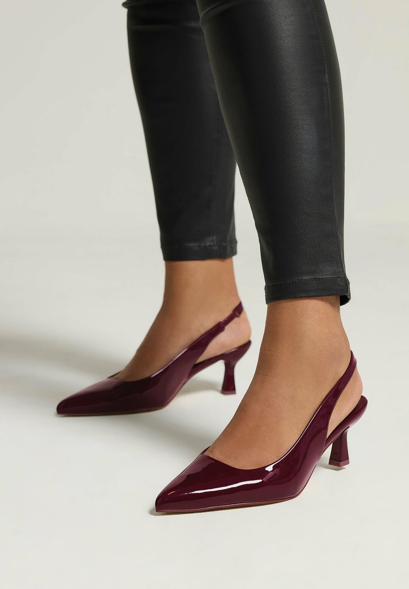 Décolleté in pelle verniciata bordeaux con punta affilata e tacco a blocco di altezza media, caratterizzati da un design elegante e apertura sulla schiena.