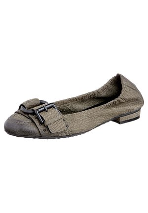 Lichtbruine damesloafer met structuur, zwarte gesp en lage hak, met zicht op de binnenkant en zooldetails op een witte achtergrond.