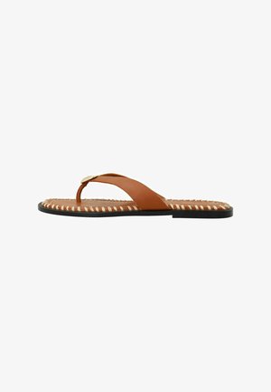 Bruine leren teenslippers met gekruiste banden, een gouden accent en een gestreepte, Textuur scheen. Kenmerkt een platte zwarte zool voor comfort.