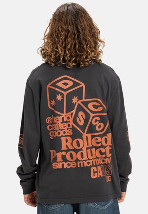 Schwarzes Langarmshirt mit orangefarbigem Grafikdruck, einschließlich Würfeln und Text. Hergestellt aus weichem Stoff mit lockerer Passform. Kein Frontdesign.