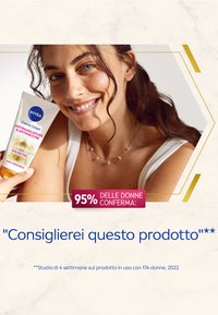 Tube di crema per il corpo NIVEA, bianca con testo blu e rosa, tenuta da una persona con capelli scuri e mossi, indossante una maglietta bianca. Superficie della crema liscia.