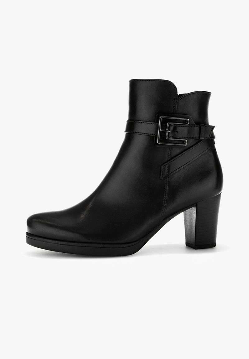 Bottette en cuir noir à la cheville avec un bout arrondi, un talon structuré et un détail de boucle sur le côté. Texture lisse et design élégant.