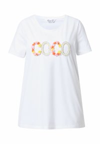 Camiseta blanca con la inscripción "COCO" adornada con flores de colores y perlas. Manga corta y cuello redondo. Material de algodón suave.