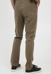 Khaki broek met een slim fit, vijf zakken en een soepele katoenen stof. Te dragen met zwarte sneakers voor contrast.
