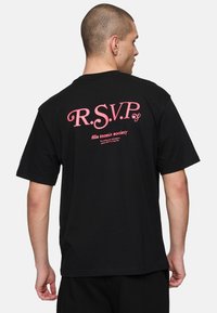 Sort bomulds T-shirt med et stort pink "R.S.V.P." grafisk tryk og tekst "fila tennis society" på ryggen, med korte ærmer og en afslappet pasform.