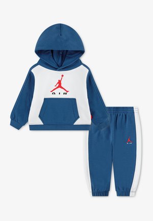 Niebiesko-biały zestaw dresowy dla małego dziecka z bluzą z kapturem i spodniami typu jogger, czerwone logo Jumpman i napis „AIR” na obu częściach.