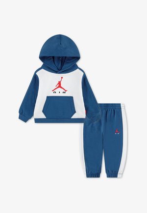 Niebiesko-biały zestaw dresowy dla małego dziecka z bluzą z kapturem i spodniami typu jogger, czerwone logo Jumpman i napis „AIR” na obu częściach.