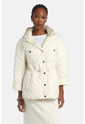 Pikowana kremowa kurtka puchowa z taliowaniem, przednimi kieszeniami i kapturem. Posiada metalowe zatrzaski i gładką fakturę.