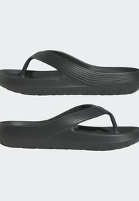 Svarta flip-flops med en slät, matt yta; med en böjd rem och texturerad sula för grepp. Lättviktig, minimalistisk design.
