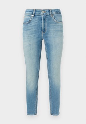 Svetlo modre ozke kavbojke z gumbi in zadrgo spredaj, pet žepov in subtilnimi zbledelimi detajli na stegnih in kolenih.