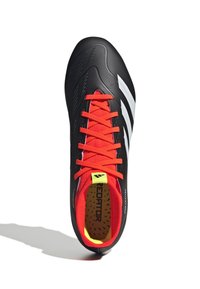 Scarpa da calcio nera con superficie testurizzata, lacci rossi e accenti gialli. Presenta tre strisce bianche e un interno imbottito con il testo "REDATOR".