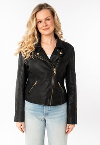 Zwart leren motorjack met een aansluitend ontwerp, schuine ritsen, gouden hardwareaccenten en een gekartelde kraag. Gelaagde afwerking.