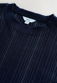 Sweat-shirt bleu marine avec des rayures blanches horizontales, coupe décontractée, col rond, et une étiquette portant la mention "NEXT" cousue dans le col intérieur.