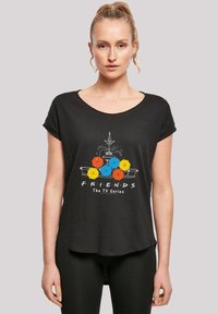 Black t-shirt with a round neckline and rolled sleeves, featuring a graphic of a fountain and colorful umbrellas with "FRIENDS The TV Series" text.